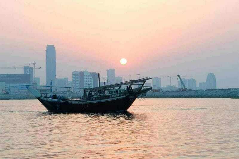 Bahrain - the city skyline, sunset and the boat in the water