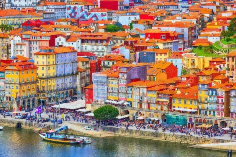 Brightly coloured red and orange roofs of Porto houses along the river bank