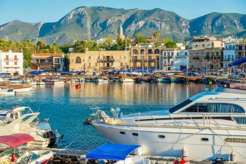 A serene and historical harbor in Kyrenia - yachts and boats surrounded by historic buildings housing cafes and restaurants.