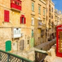 Valletta, Malta - street view with traditional British red phone box and red Maltese balconies