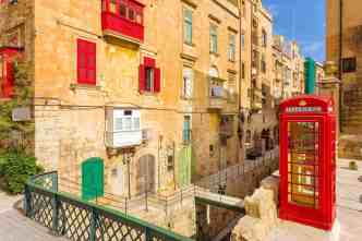 Valletta, Malta - street view with traditional British red phone box and red Maltese balconies