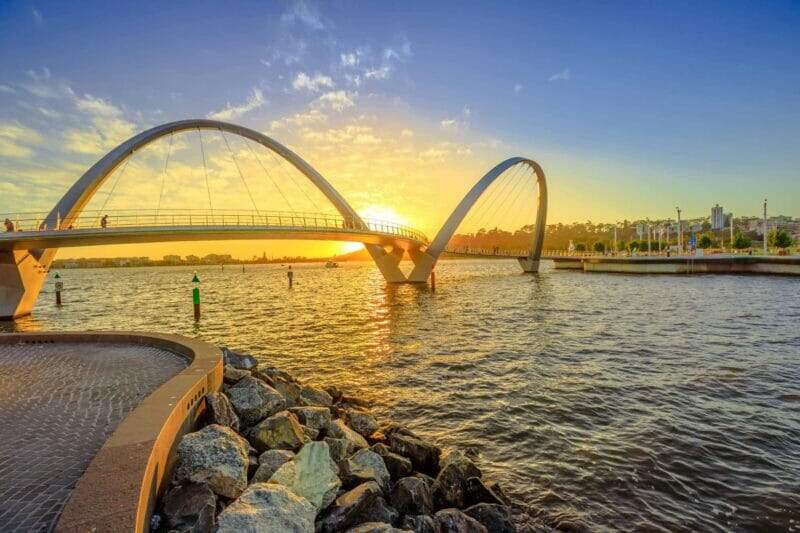 Elizabeth Quay Bridge in Perth - a modernistic looking bridge across the water reflecting the setting sun.