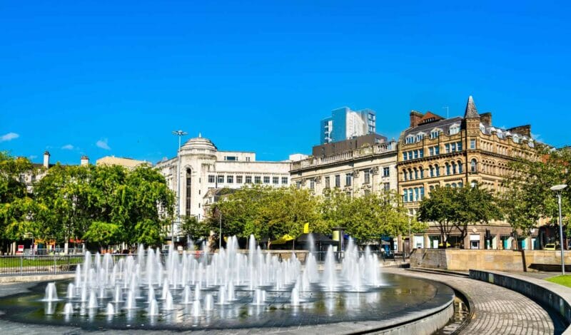 Manchester city square with working fountains on a summer day