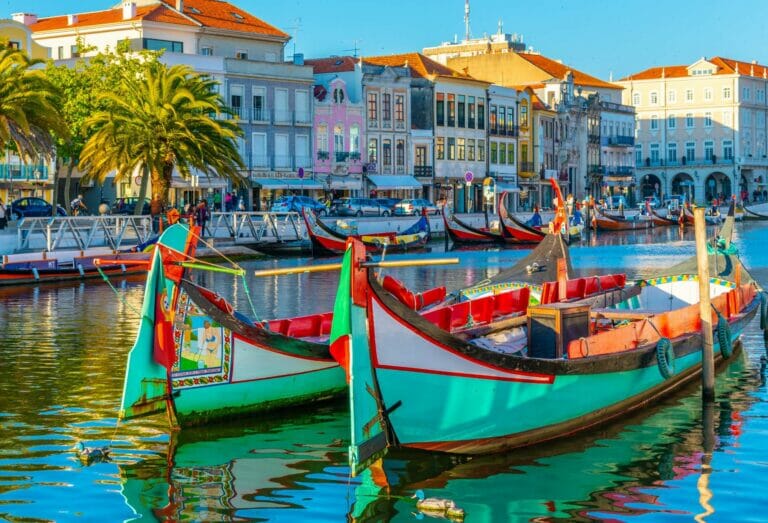 Colourful rowing boats moored along the canal in Aveiro on a sunny day.