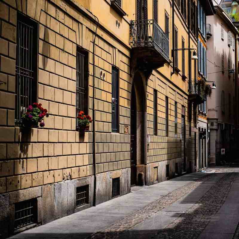 Narrow street flanked by historical buildings in Brera, Milan