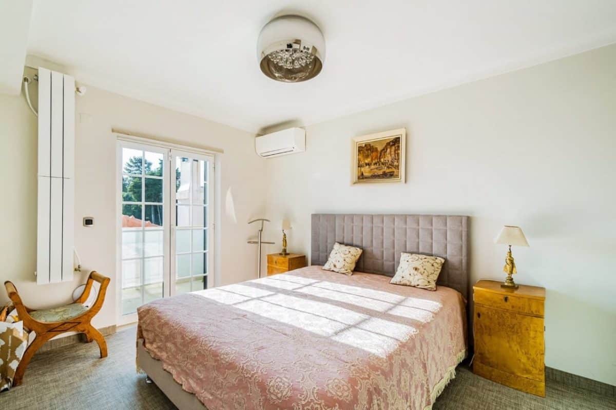 A light and big bedroom with a French window and a double bed