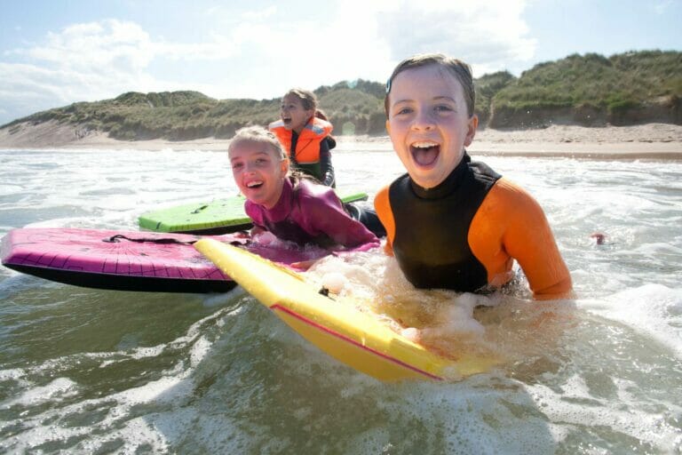 Three children body surfing laughing and happy
