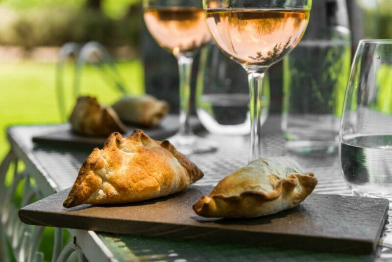 two glasses of wine on the table and traditional pastries - empanadas