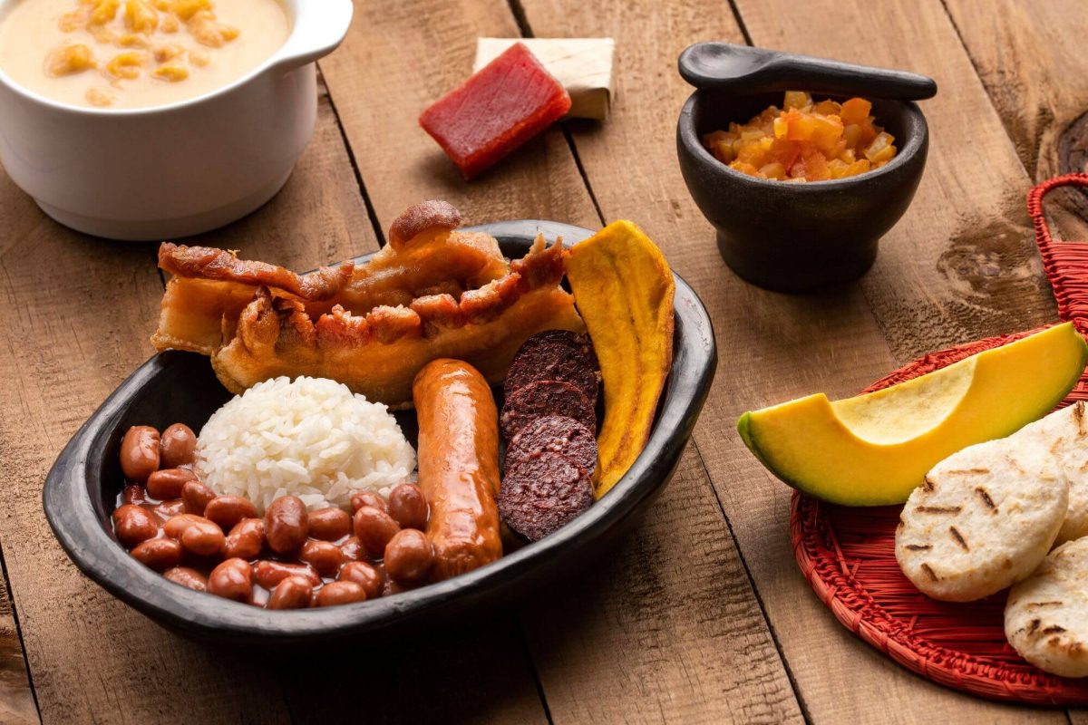 A dish of rice, beans and sausages served with bread and dips