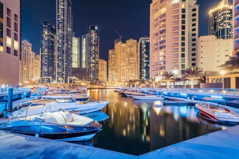 Luxury yachts moored in Dubai Marina lit up at night