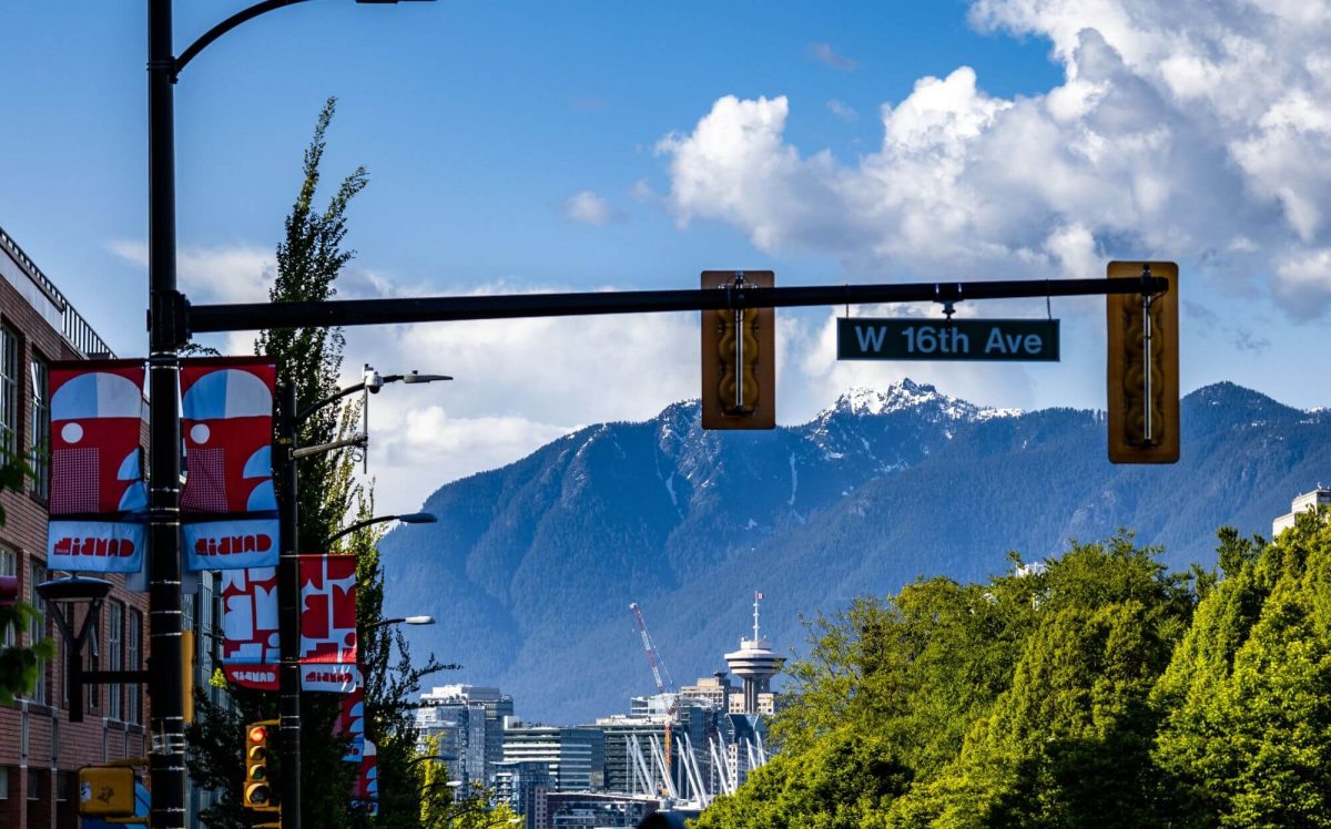 A green neighborhood of Mount Pleasant in Vancouver with mountains in the background