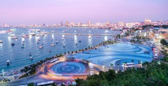 A view of Pattaya city from the elevation of the Viewpoint at night with bright city lights and the boats in the sea.