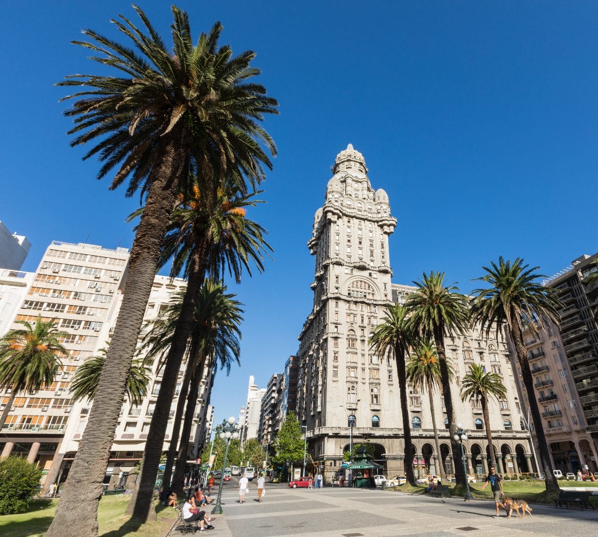 A central street in Montevideo featuring Salvo Palace (Palacio Salvo), a historical landmark building in an eclectic architectural style—predominantly Italian Gothic