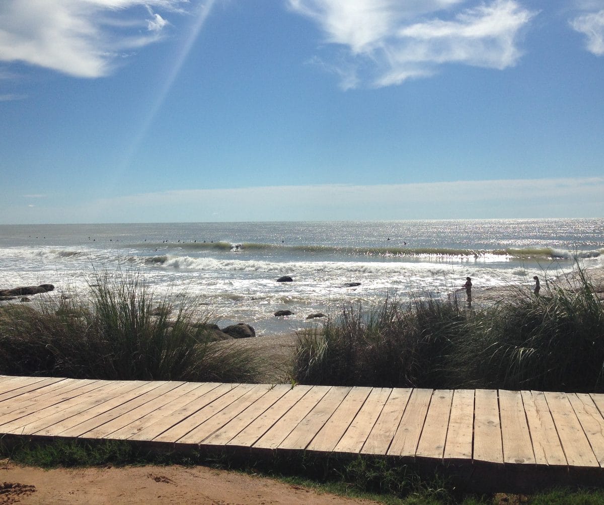 A wooden walkway among the sandy coast of Punta del Diablo in Uruguay